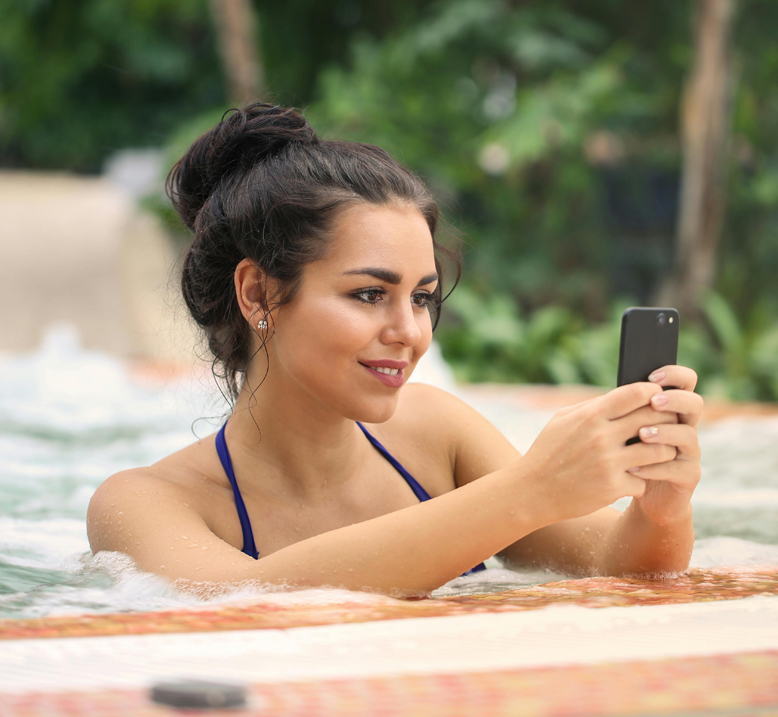 woman holding a phone in a pool.