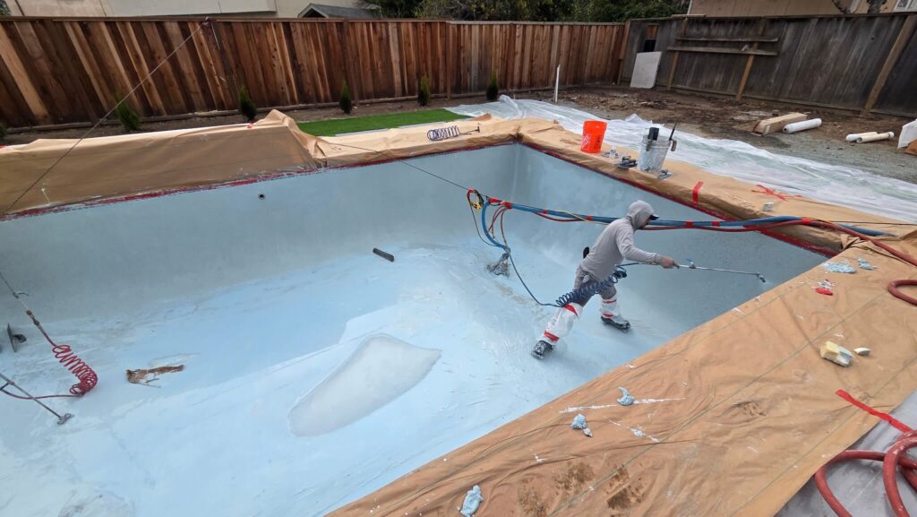 Application of pebble resurfacing to a pool.